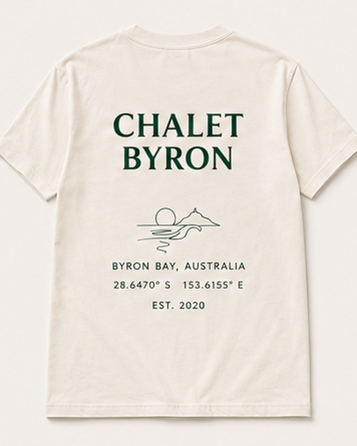 The Back Print tee from the back: a large Chalet Byron wordmark, a line drawing of the sun and the headland, Byron Bay, Australia, the coordinates and Est. 2020