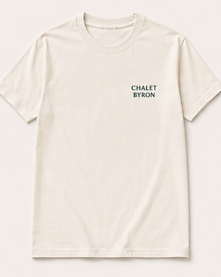 The Minimalist tee from the front: an off-white tee with a small Chalet Byron wordmark on the left chest